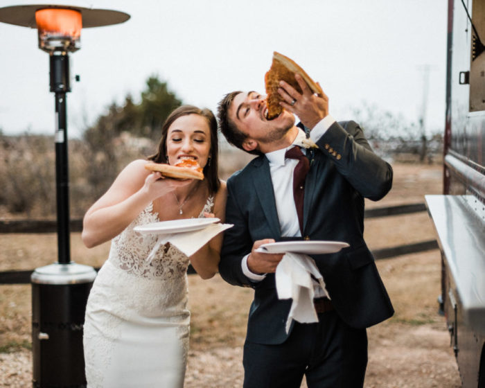 Pinterest worthy of photo of a bride and Groom enjoying slices of pizza