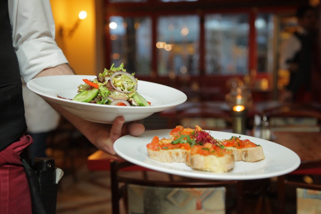 A chef serving a plated dinner